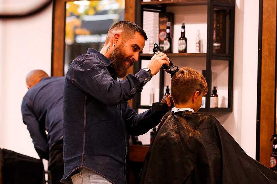 barbero haciendo corte a cliente maj barber