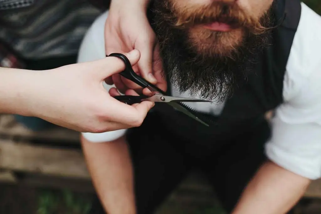 barbero cortando barba tijeras